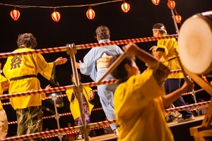 Dancing people of Bon Dance and a man beating Japanese drum