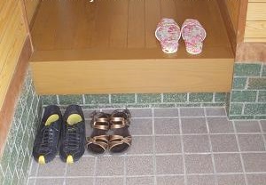 An entrance of Japanese house where a few shoes are put