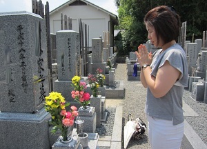 A woman visits her ancestor's grave and worships