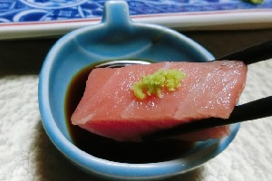 Sashimi dipped in shoyu with wasabi
