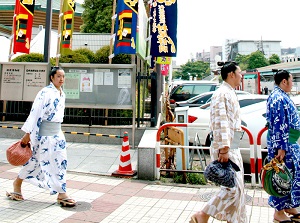 Young sumo wrestlers walking around arena