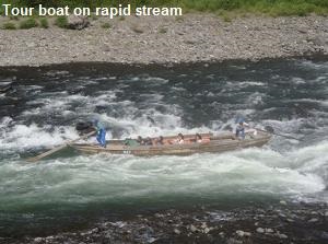 Tour boat on rapid stream of Kuma River